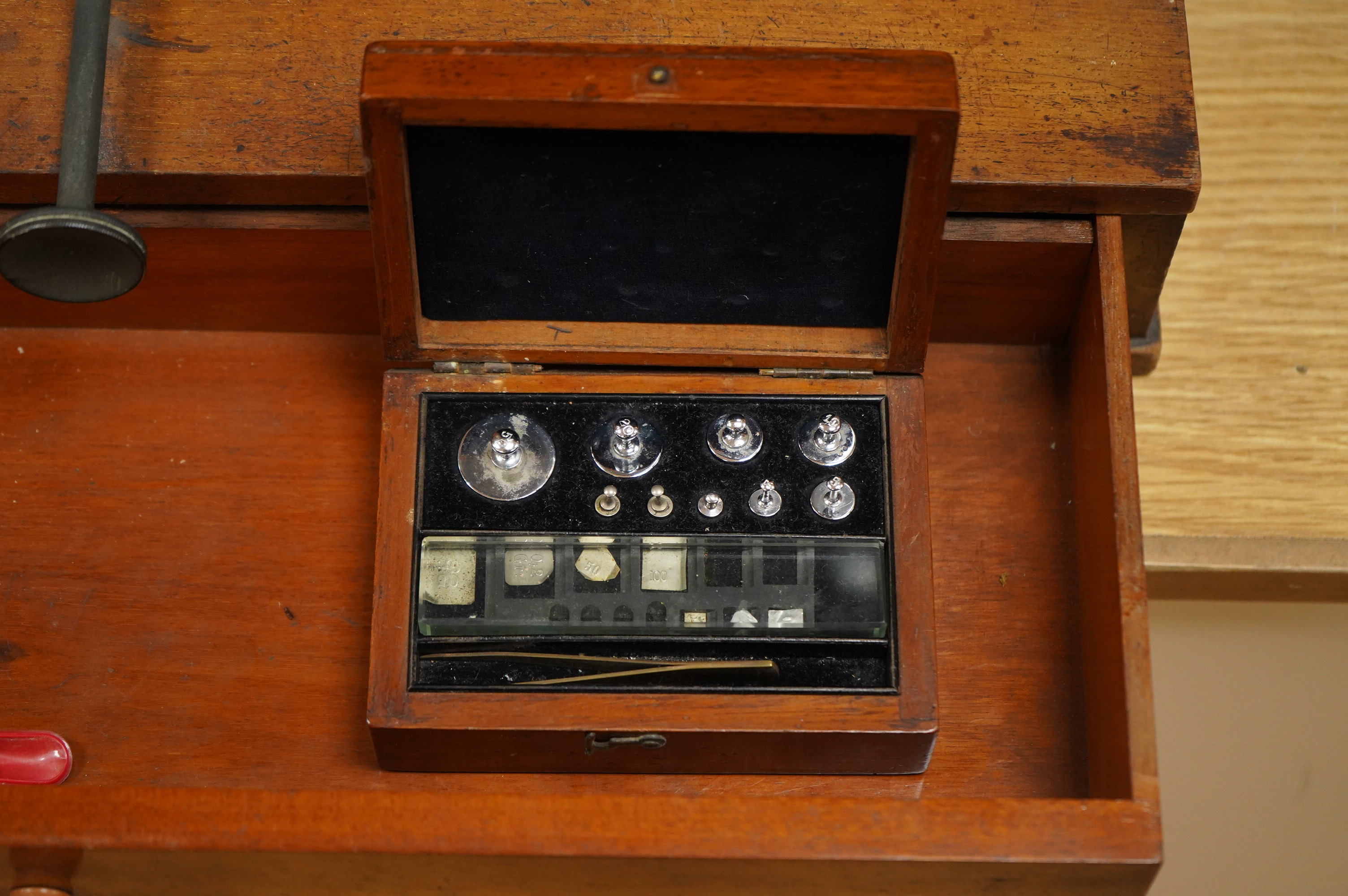 An early 20th century glazed mahogany cased laboratory chemical balance by Oertling, London, the drawer housing a set of weights, 45.5cm high, 50cm wide, 26cm deep